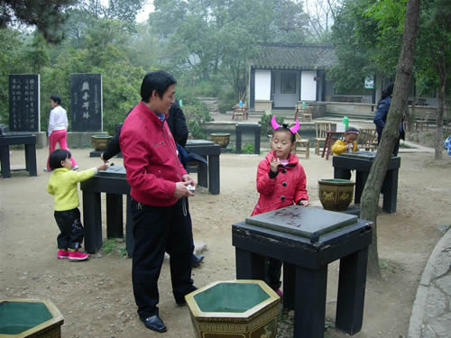 碑林の前で水書きを楽しむ中国の子供